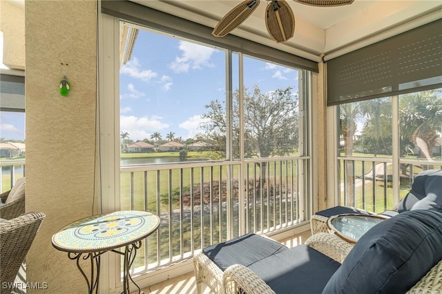 sunroom featuring a water view