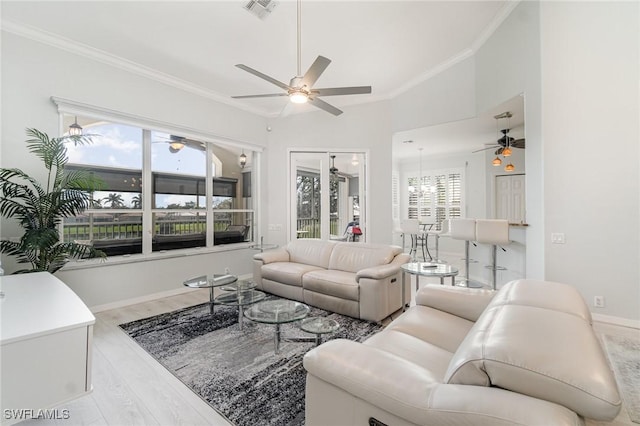 living area with ceiling fan with notable chandelier, wood finished floors, visible vents, baseboards, and crown molding