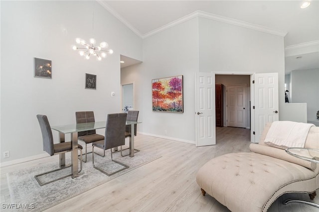 dining area with light wood-style floors, a chandelier, high vaulted ceiling, and ornamental molding