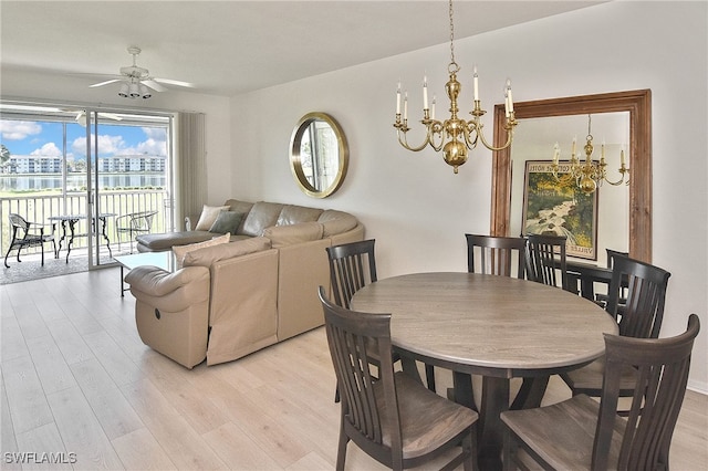 dining space with light wood-style flooring and ceiling fan with notable chandelier