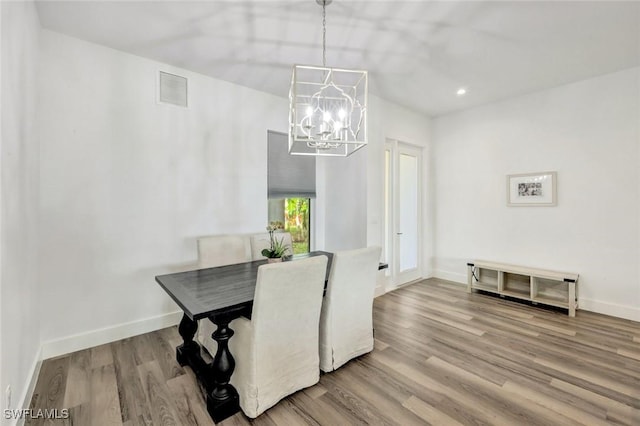 dining space with a chandelier, wood finished floors, baseboards, and recessed lighting