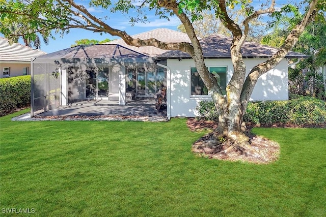 rear view of property with a patio area, a lawn, and stucco siding