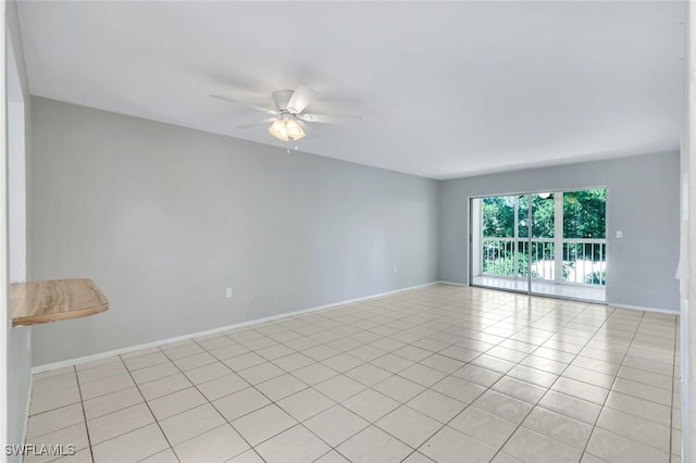 spare room featuring a ceiling fan and baseboards