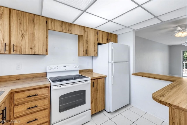 499 Forest Lakes Blvd Unit 312, Naples, FL 34105 - kitchen with brown cabinets, light tile patterned flooring, white appliances, a ceiling fan, and a drop ceiling