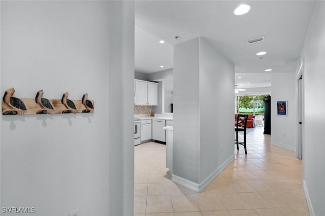 hallway featuring recessed lighting, light tile patterned flooring, visible vents, and baseboards