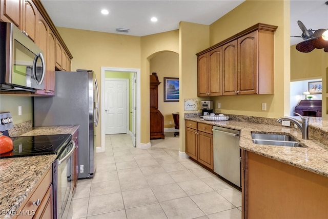 kitchen featuring visible vents, appliances with stainless steel finishes, light stone countertops, a sink, and light tile patterned flooring