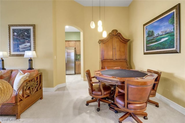 recreation room featuring arched walkways, baseboards, and light colored carpet