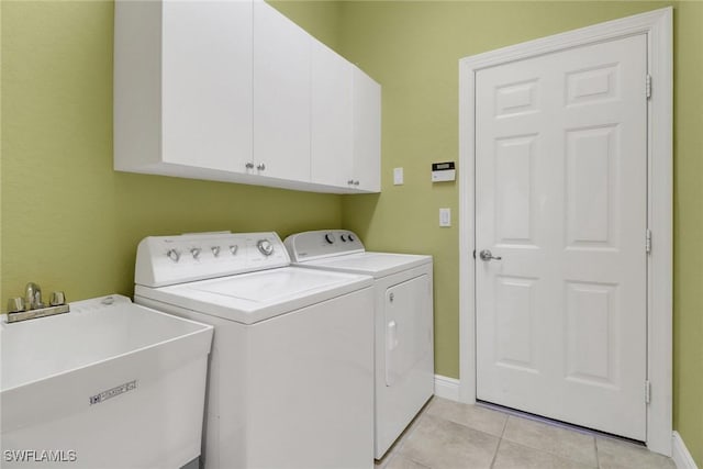 laundry room with light tile patterned floors, separate washer and dryer, a sink, baseboards, and cabinet space