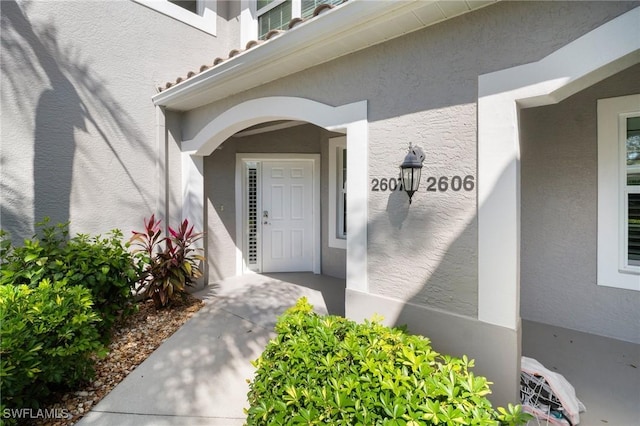 entrance to property featuring stucco siding