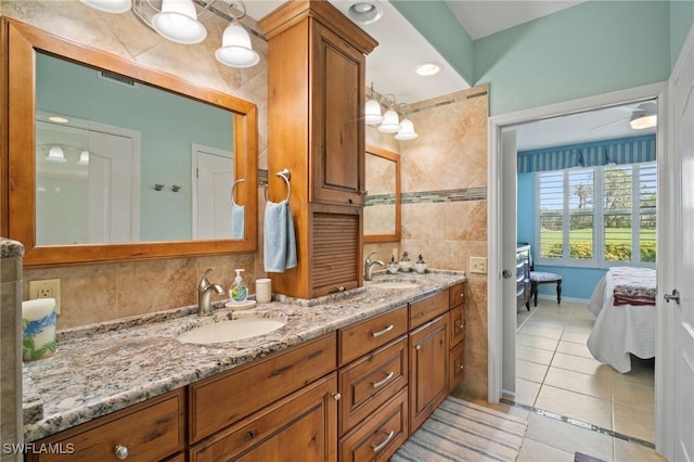 ensuite bathroom featuring ensuite bathroom, double vanity, tile patterned flooring, and a sink