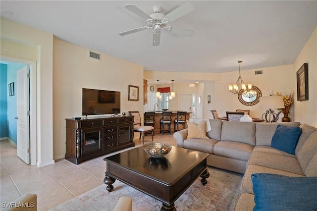 living area with ceiling fan with notable chandelier, visible vents, baseboards, and light tile patterned floors