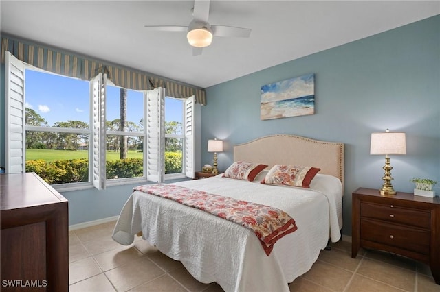 bedroom with a ceiling fan, tile patterned flooring, and baseboards