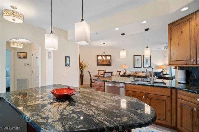 kitchen with arched walkways, visible vents, stainless steel dishwasher, brown cabinetry, and a sink