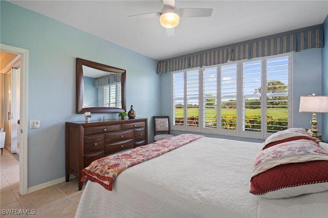 tiled bedroom featuring a ceiling fan and baseboards