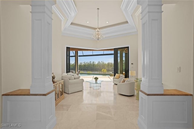 living area featuring decorative columns, ornamental molding, and a towering ceiling