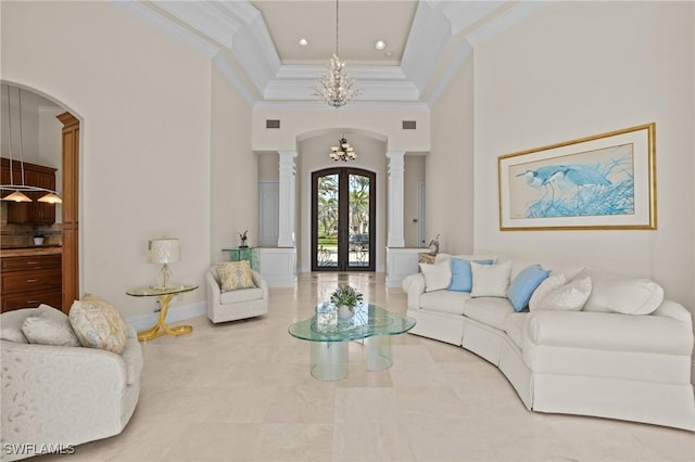 living area featuring visible vents, ornamental molding, french doors, arched walkways, and ornate columns