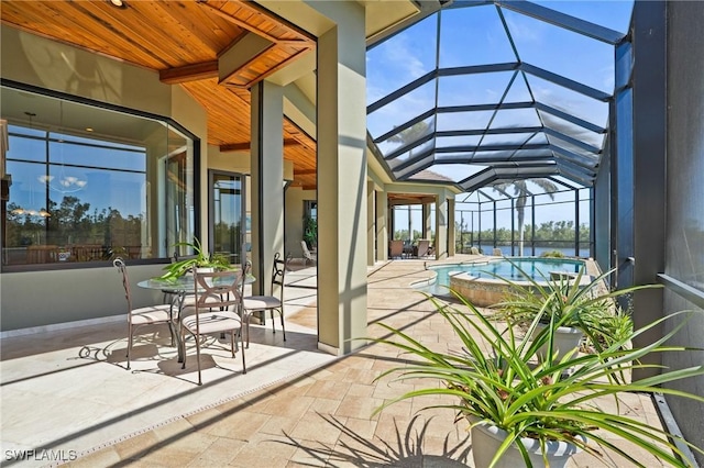 view of patio / terrace with a lanai, an in ground hot tub, and an outdoor pool