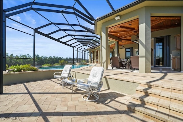 view of patio featuring a lanai and a pool with connected hot tub