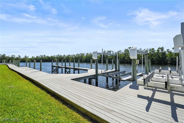 view of dock with boat lift, a yard, and a water view