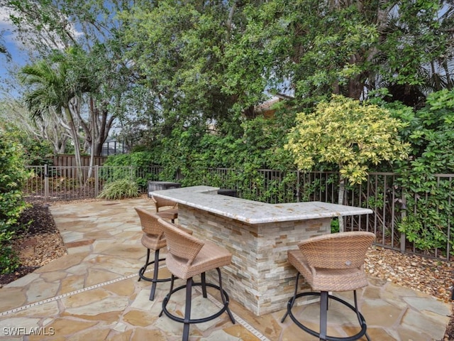 view of patio with fence and outdoor dry bar