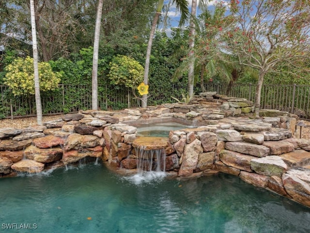 exterior space with fence and an in ground hot tub