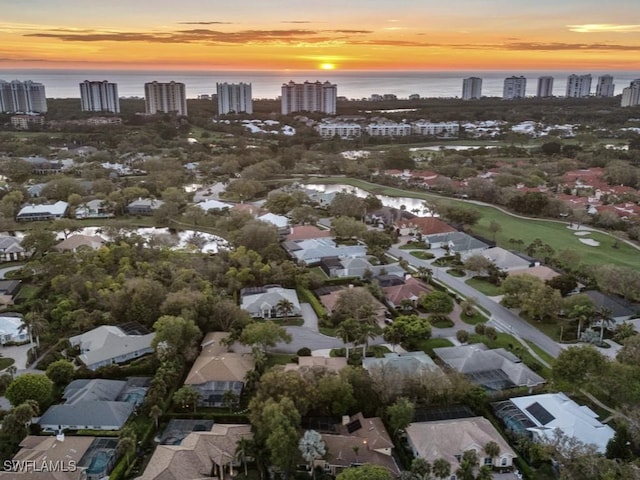 aerial view at dusk with a view of city and a water view