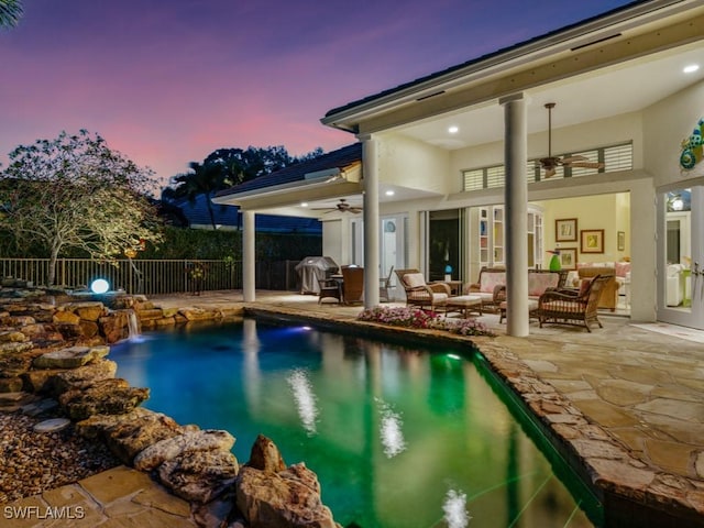 pool at dusk with a fenced in pool, area for grilling, a patio, ceiling fan, and fence