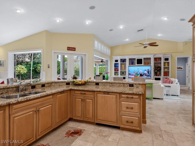 762 Lynnmore Ln E, Naples, FL 34108 - kitchen with stone tile flooring, lofted ceiling, ceiling fan, light stone counters, and a sink