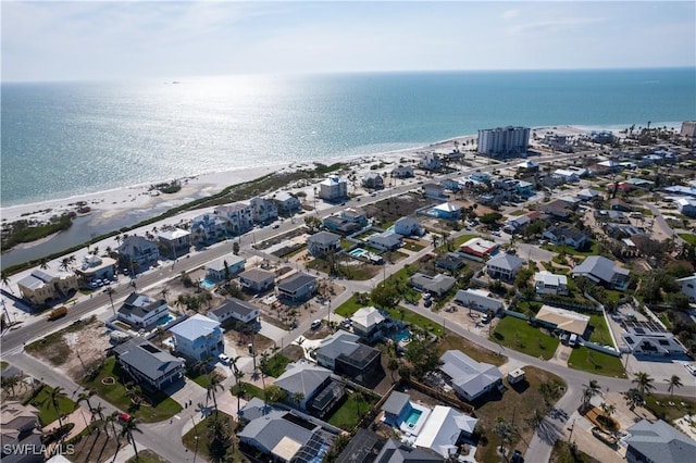 birds eye view of property featuring a beach view, a water view, and a residential view