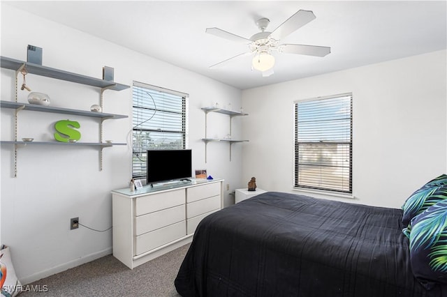 bedroom with a ceiling fan, multiple windows, light carpet, and baseboards