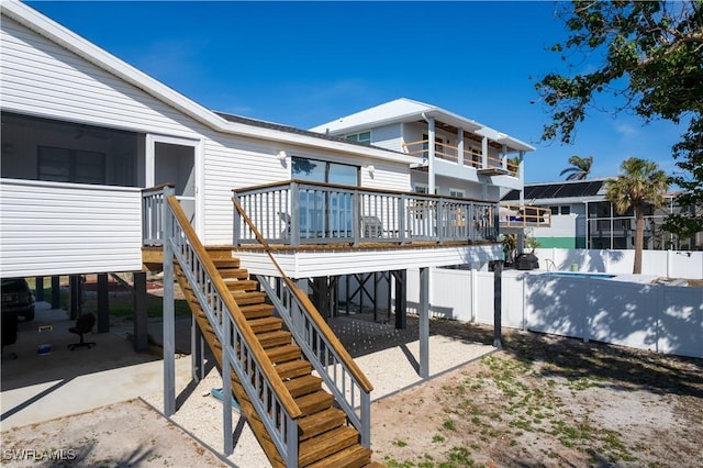 exterior space featuring fence, a deck, and stairs