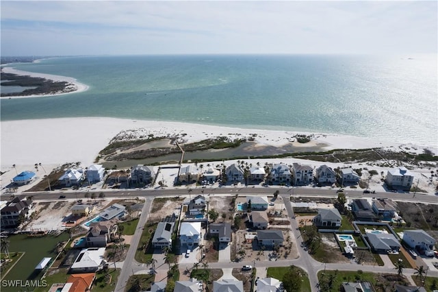 birds eye view of property featuring a beach view, a water view, and a residential view