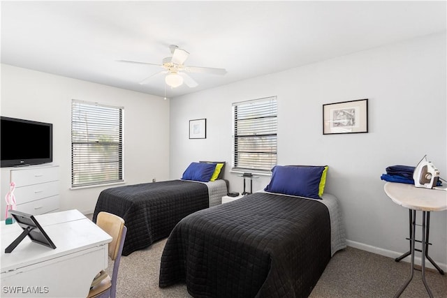 bedroom featuring multiple windows, baseboards, a ceiling fan, and light colored carpet