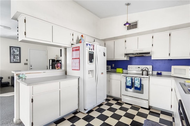 kitchen featuring white appliances, visible vents, dark floors, and white cabinetry