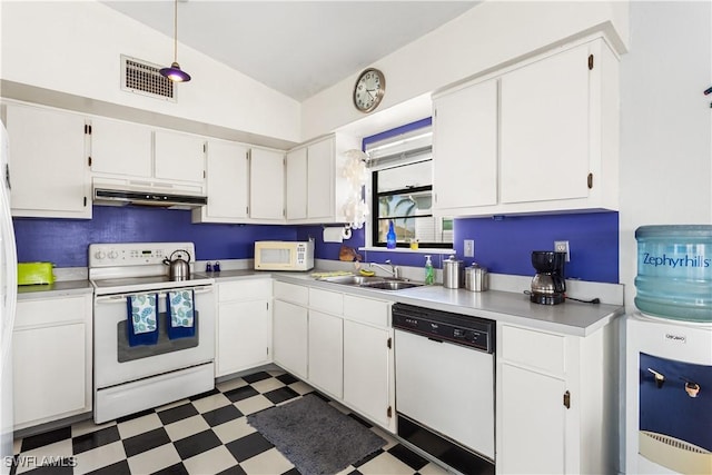 kitchen with light countertops, dark floors, white appliances, and white cabinets