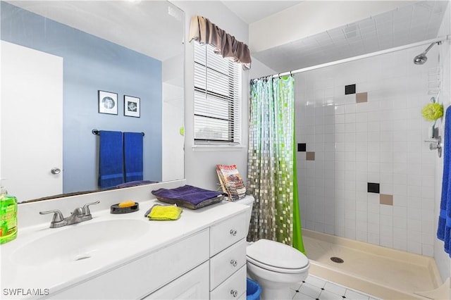 bathroom featuring toilet, vanity, and a shower stall