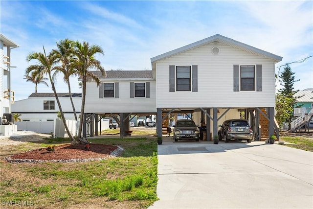 beach home with driveway, a carport, and stairs