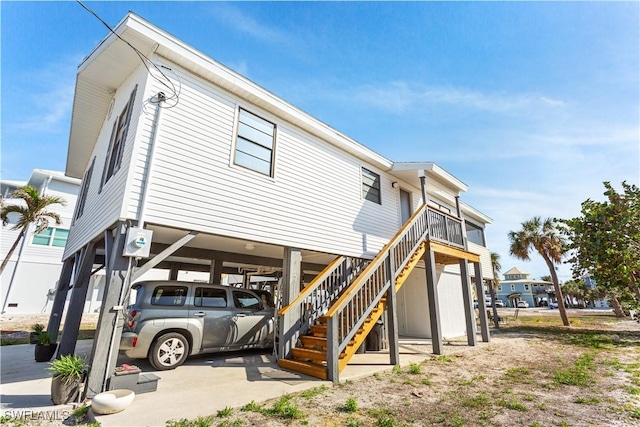 back of property featuring a carport and stairs