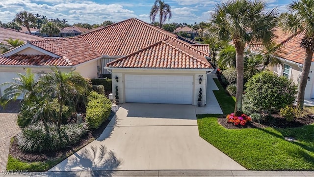 mediterranean / spanish house featuring a garage, stucco siding, concrete driveway, and a tiled roof