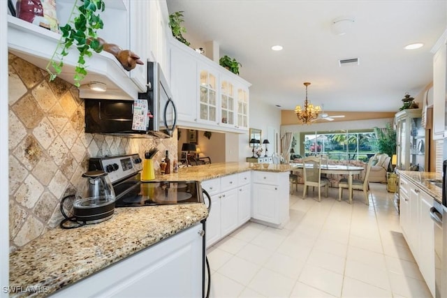 kitchen with white cabinets, decorative backsplash, glass insert cabinets, a peninsula, and stainless steel appliances