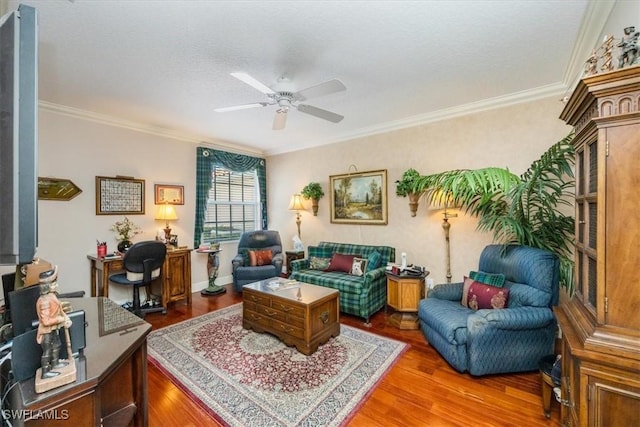 living area featuring a ceiling fan, a textured ceiling, ornamental molding, and wood finished floors