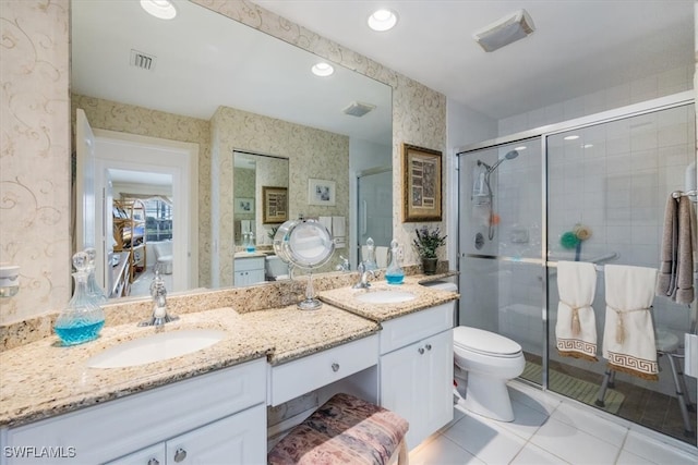 bathroom featuring a sink, a shower stall, and wallpapered walls