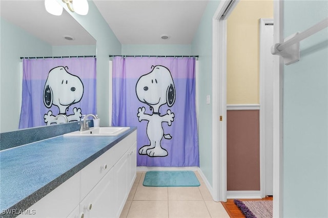 full bathroom featuring tile patterned flooring, vanity, and baseboards