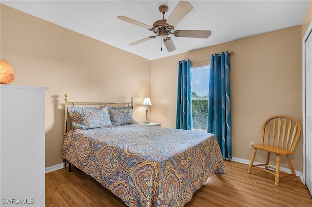 bedroom with ceiling fan, baseboards, and wood finished floors