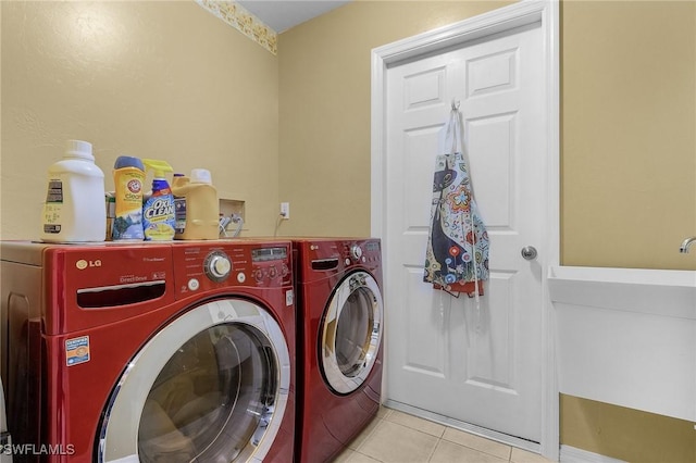 laundry room featuring light tile patterned floors, laundry area, and washing machine and clothes dryer