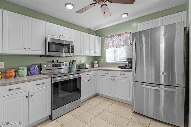 kitchen featuring light tile patterned floors, stainless steel appliances, white cabinetry, a ceiling fan, and light countertops