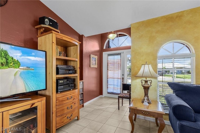 home office with built in shelves, vaulted ceiling, light tile patterned flooring, and plenty of natural light