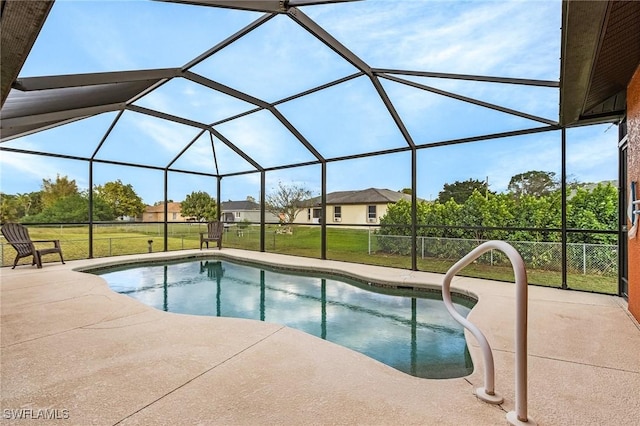 pool featuring glass enclosure, a patio area, and a lawn