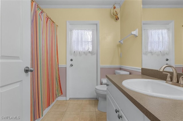 bathroom with tile patterned flooring, crown molding, vanity, and toilet