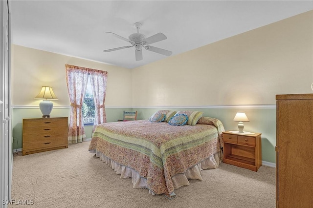 bedroom with light colored carpet, ceiling fan, and baseboards